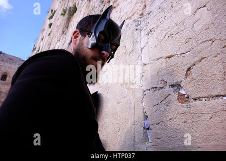 Ein religiöser Jude tragen Batman Maske während des jüdischen Festivals von Purim in der Klagemauer oder Kotel in der Altstadt Ost-Jerusalem Israel Stockfoto