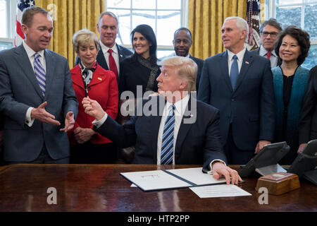 Washington DC, USA 13. März 2017 uns Präsident Donald J Trump (C) die Hände seiner Feder, Direktor von der Office of Management and Budget (OMB) Mick Mulvaney (Front L), nach der Anmeldung eine Executive Order mit dem Titel "Gesamtplan zur Neuordnung der Rechtshilfe Stockfoto