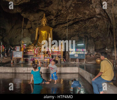 Kanchanaburi, Thailand. 15. November 2006. Eine thailändische Familie in Tham Krasae (Krasae Höhle), ein Tempel-Höhle mit einer riesigen goldenen Buddha-Statue und zahlreiche heilige Buddha-Figuren. Es blickt auf den Khwae Noi Fluss nahe dem Wang-Pho-Bahnhof im Westen Thailands. Im 2. Weltkrieg diente es als Campingplatz und Feldlazarett für japanische Soldaten verantwortlich für die alliierten Kriegsgefangenen Bau der berüchtigten Thailand-Burma-Eisenbahn. Bildnachweis: Arnold Drapkin/ZUMA Draht/Alamy Live-Nachrichten Stockfoto