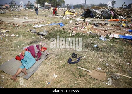 Kathmandu, Nepal. 14. März 2017. Eine nepalesische Frau Nickerchen auf dem Boden, nachdem ihr behelfsmäßigen Schutz von der Polizei in einem Hubraum-Camp für die Erdbebenopfer in Chuchepati, Kathmandu, Nepal auf Dienstag, 14. März 2017 abgerissen wurde. Mehr als Hunderte von Opfern lebten im Lager nach dem Verlust ihrer Häuser in 2015 Erdbeben. Bildnachweis: Skanda Gautam/ZUMA Draht/Alamy Live-Nachrichten Stockfoto