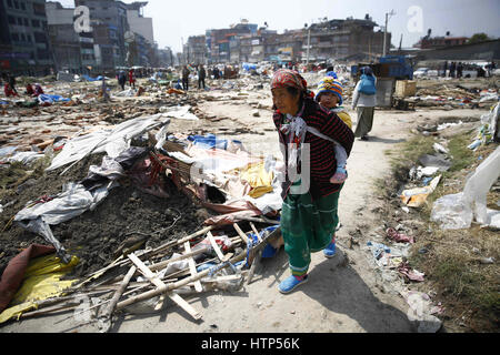 Kathmandu, Nepal. 14. März 2017. Eine nepalesische Frau geht mit ihrem Kind nach behelfsmäßigen Schutz von der Polizei in einem Hubraum-Camp für die Erdbebenopfer in Chuchepati, Kathmandu, Nepal auf Dienstag, 14. März 2017 abgerissen wurde. Mehr als Hunderte von Opfern lebten im Lager nach dem Verlust ihrer Häuser in 2015 Erdbeben. Bildnachweis: Skanda Gautam/ZUMA Draht/Alamy Live-Nachrichten Stockfoto