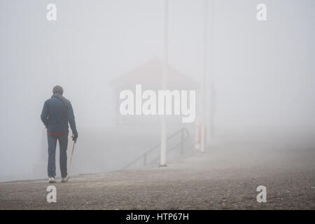 Aberystwyth, Wales, UK. 14. März 2017. UK-Wetter: Menschen zu Fuß entlang der Promenade werden durch den Nebel in der Stadt von Aberystwyth Resort an der Westküste von Wales verdeckt, wie eine dicke Decke des grauen Meeres Kaltnebel wirbelnden kommt in aus der irischen See heute Nachmittag. Bildnachweis: Keith Morris/Alamy Live-Nachrichten Stockfoto