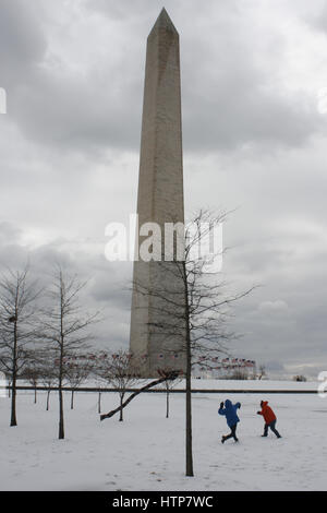 Washington, DC, USA. 14. März 2017. Das Washington Monument ist ersichtlich, mit zwei Kindern mit einer Schneeballschlacht in der Nähe, nach '' Winter Sturm Stella'' Washington, DC mit ein paar Zentimeter Schnee bedeckt. Bildnachweis: Evan Golub/ZUMA Draht/Alamy Live-Nachrichten Stockfoto