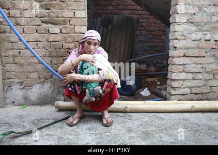 Dhaka, Bangladesch. 16. März 2017. Eine Frau, die ihr alles verloren, sitzt mit ihrem großen Kind unter freiem Himmel nach Flammen an einem der größten Slums in der Hauptstadt Dhaka, Bangladesch, 16. März 2017 ausbrach. Mehr als 40.000 Menschen sind betroffen, wie Mut zu feuern, die mehr als 500 Shanties in Korail in Dhaka Mohakhali Bereich heute Slum. Bildnachweis: Suvra Kanti Das/ZUMA Draht/Alamy Live-Nachrichten Stockfoto