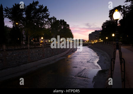 Granada Spanien Fluss Genil nachts Mäandern durch Plaza de Humillaredo mit den Straßenlaternen gegen die Dämmerung Himmel Stockfoto