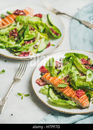 Gesunde Energie fördernde Frühlingssalat mit gegrillten Lachs, Blutorange, Oliven, Gurken und Quinoa in grauem Marmor Hintergrund, selektiven Fokus. Clea Stockfoto