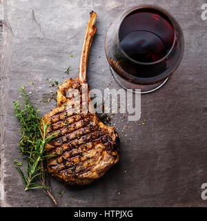 Gegrilltes Rindfleisch Grillen Kalbfleisch Rib Steak auf Knochen und Rotwein auf Stein Schiefer Hintergrund Stockfoto