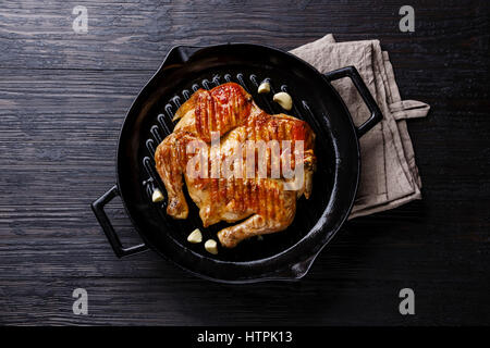 Vom Grill gebratene gebratenes Hähnchen Tabaka in Pfanne auf hölzernen Hintergrund Stockfoto