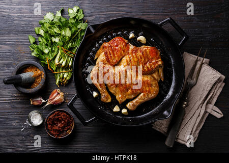 Vom Grill gebratene gebratenes Hähnchen Tabaka in Pfanne auf hölzernen Hintergrund Stockfoto