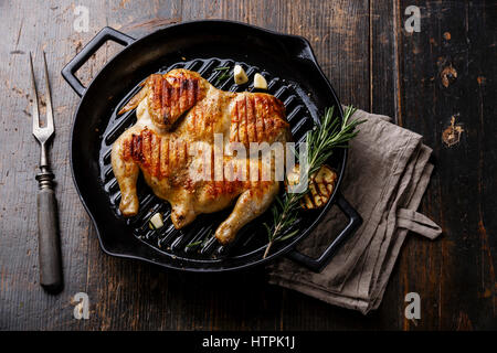 Vom Grill gebratene gebratenes Hähnchen Tabaka in Pfanne auf hölzernen Hintergrund Stockfoto