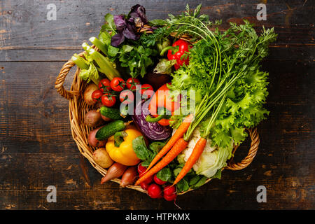 Frisches Gemüse im Korb auf hölzernen Hintergrund Stockfoto