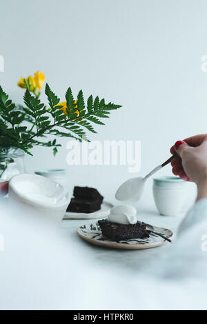Hand Creme auf der Oberseite der Brownie setzen Stockfoto