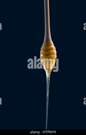 Honig-Stick auf schwarzem Hintergrund Stockfoto