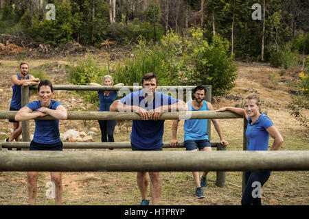 Gruppe von Menschen stützte sich auf Hürden beim Hindernis Training im Boot camp Stockfoto