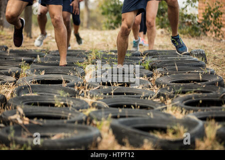 Niedrigen Bereich der Bezieher Reifen-Hindernis-Parcours-Training im Boot camp Stockfoto