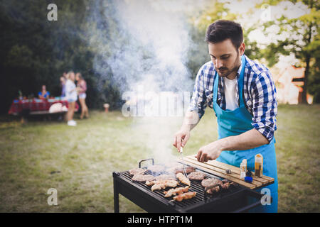 Glücklich männlich Grillen Bbq Fleisch im Freien in der Natur Stockfoto