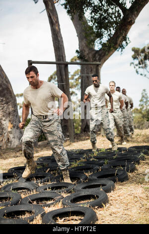 Junge Militär Soldaten üben Reifen-Hindernis-Parcours im Boot camp Stockfoto