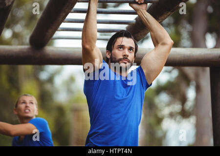 Fit Mann Klettern Klettergerüst im bootcamp Stockfoto