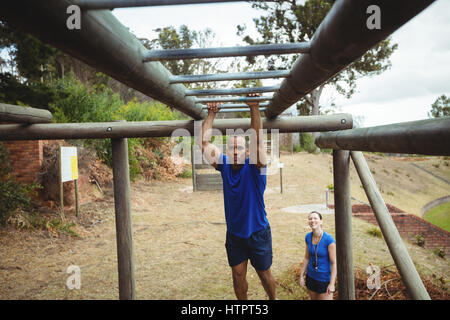 Fit Mann Klettern Klettergerüst im bootcamp Stockfoto