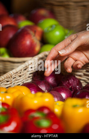 Hand des weiblichen Kunden Weidenkorb im organischen Bereich Gemüse auswählen Stockfoto
