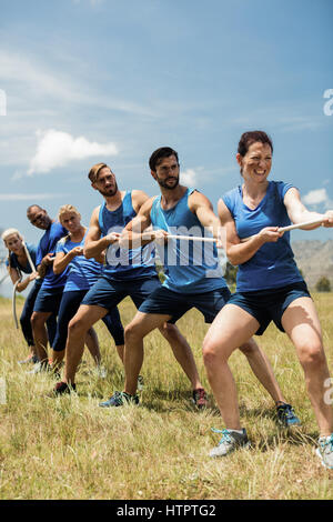 Menschen spielen Tauziehen während Training Parcours im Ausbildungslager Stockfoto