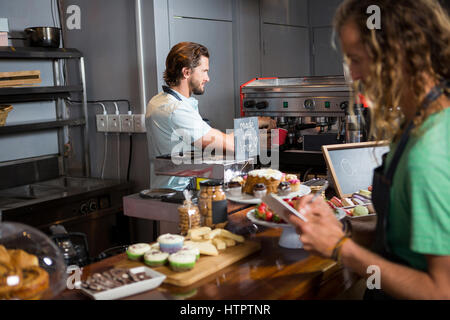 Zwei männliche Mitarbeiter am Counter im Coffee-shop Stockfoto