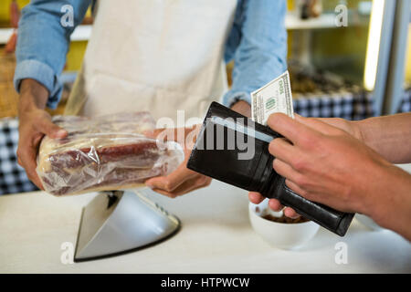 Personal Zahlungseingang vom Kunden in Fleischerei Stockfoto