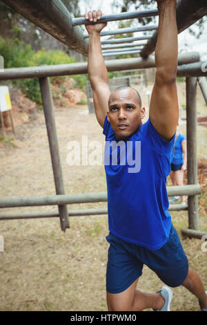 Fit Mann Klettern Klettergerüst im bootcamp Stockfoto