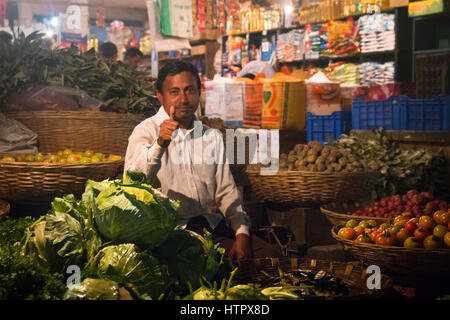 SRIMANGAL, Bangladesch - Februar 2017: Mann mit einen kleinen Laden mit Gemüse auf dem zentralen Bazar Markt in Srimangal, Bangladesch Stockfoto