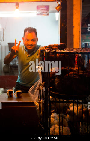 SRIMANGAL, Bangladesch - Februar 2017: Mann mit einen kleinen Laden mit Huhn auf dem zentralen Bazar Markt in Srimangal, Bangladesch Stockfoto