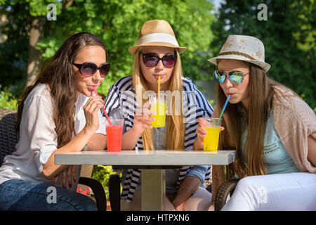 Drei attraktive Freundinnen genießen Sie Cocktails in einem Café im Freien, Freundschaft Konzept Stockfoto