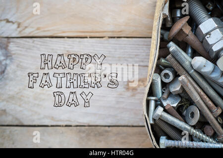 Väter Tag Konzept, Schachtel mit alten rostigen Metallschrauben auf hölzernen Hintergrund Stockfoto
