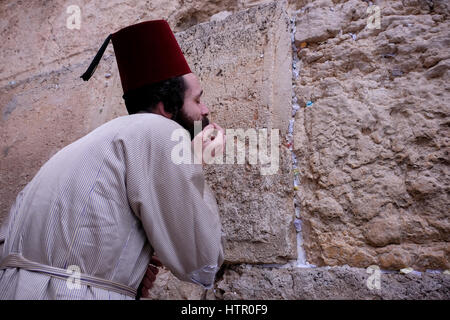 Ein Ultra orthodoxer Jude tragen eine traditionelle muslimische Tarbusch oder Fez Hut Kostüm beten während des jüdischen Festivals von Purim in der Klagemauer oder Kotel in der Altstadt Ost-Jerusalem Israel Stockfoto