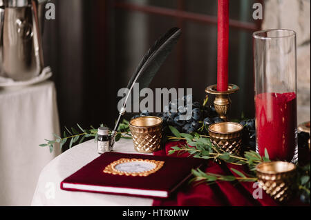 WEINIG von Hochzeitsalbum mit Kugelschreiber und Kerzen auf dem weißen Tisch Stockfoto
