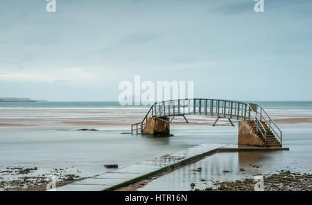 Die Fußgängerbrücke ist nur bei Ebbe befahrbar und wird Bridge to Nowhere genannt, umgeben von Hochzeitenwasser, Belhaven Bay, Dunbar, East Lothian, Schottland, Großbritannien Stockfoto