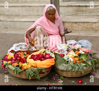 Frau verkaufen Blumen auf der Straße in der Nähe von einem Hindu-Tempel in der Altstadt, Udaipur, Rajasthan, Indien Stockfoto