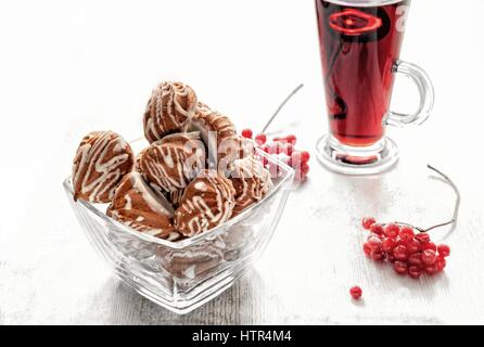 Profiteroles, Kekse, gefüllt mit Obstkonfitüre, rund, mit Tee in klarem Glas Tassen Stockfoto