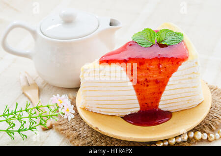 Krepp-Kuchen mit Erdbeer-Sauce auf Teller gießen Stockfoto