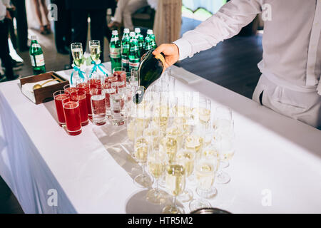 Man gießt Champagner Gläser auf einem Tisch, Nahaufnahme Stockfoto