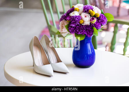 Brautstrauß rosa und lila Blumen in blauer Vase mit Bräute weiße Schuhe Stockfoto