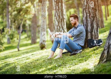 Gut aussehend Geschäftsmann mit TabletPC im park Stockfoto