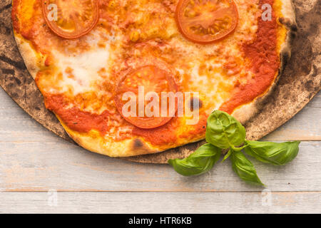 Feshly Holz gefeuert Pizza auf dem Pizzastein auf rustikale graue Boards von oben gesehen Stockfoto