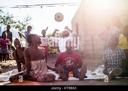 Kinder spielen Volleyball sitzen zu Hause des Glücks in Lusaka, Sambia. Heimat des Glücks für Kinder mit Behinderungen ist ein Waisenhaus gegründet, im Jahr 2015. Es gibt 62 Kinder in der Mitte, 25 davon leben dauerhaft in die Heimat des Glücks. Zwanzig Freiwillige kümmern sich um die jungen und Mädchen mit verschiedenen Arten von Behinderungen. House of Happiness befindet sich in zwei Räumen zu bauen, ohne irgendwelche Einrichtungen. Volunteers Essen am Feuer zubereiten, waschen Sie die Kleidung der Kinder außerhalb. Stockfoto