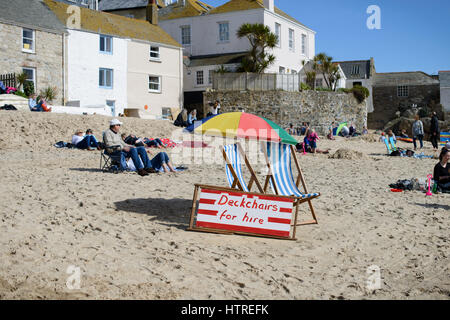 Liegestühle zu mieten auf einem sandigen Strand an einem sonnigen Tag in St. Ives, Cornwall, England. Stockfoto