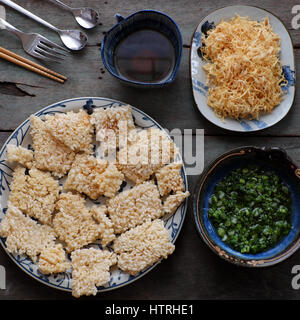 Vietnamesische Speisen, gebratener getrockneter Reis mit Schweinefleisch Zahnseide heißt com Chay Cha Bong, einen leckeren Snack Essen, Frau Hand Prozess zu Hause für die Lebensmittelsicherheit Stockfoto