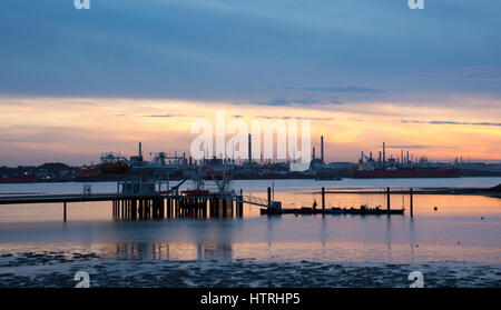 Sonnenuntergang auf dem Solent, Hampshire, UK zeigt Warsash Steg mit Fawley Ölraffinerie im Hintergrund Stockfoto