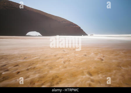 Langzeitbelichtung der roten Bögen und felsigen Strand am Atlantik in der Region Sous-Massa-Draa, Sidi Ifni, Legzira, Marokko, Afrika. Stockfoto