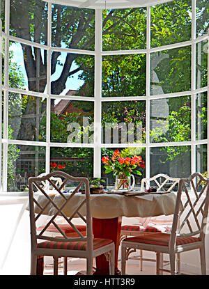 Erker mit Tisch und Stühlen mit Blick auf Garten. Stockfoto