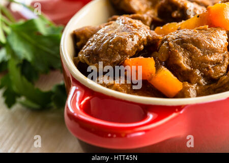 Rindfleischeintopf mit Karotten. Traditionelle französische Rindergulasch in rotem Keramiktopf Stockfoto