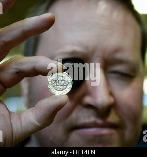 &ETH; KEINE KOMMERZIELLE NUTZUNG Royal Mint Circulating Coin Press Setter Hywel Price inspiziert eine 12-seitige 1-Pfund-Münze mit Augenglas, wie sie in der Royal Mint in Llantrisant, Wales, geprägt wird. Stockfoto